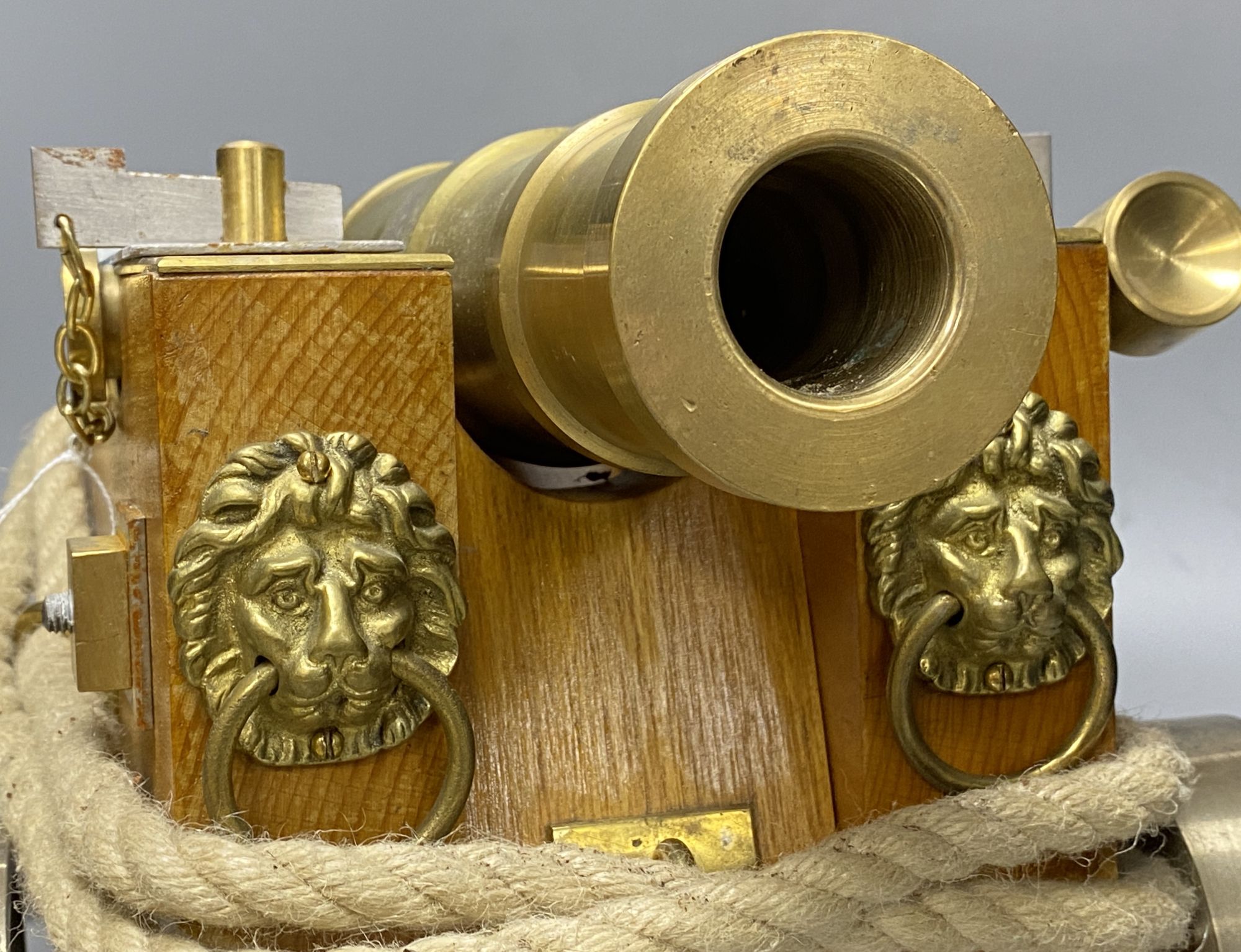 A bronze model of a cannon, on stepped wheel base with lion head motifs, length 50cm